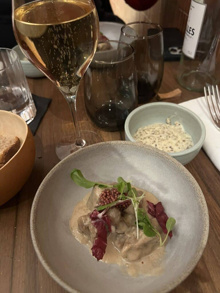 Plat gourmet chez Table Penja, meilleur restaurant africain 2025 avec verre de champagne